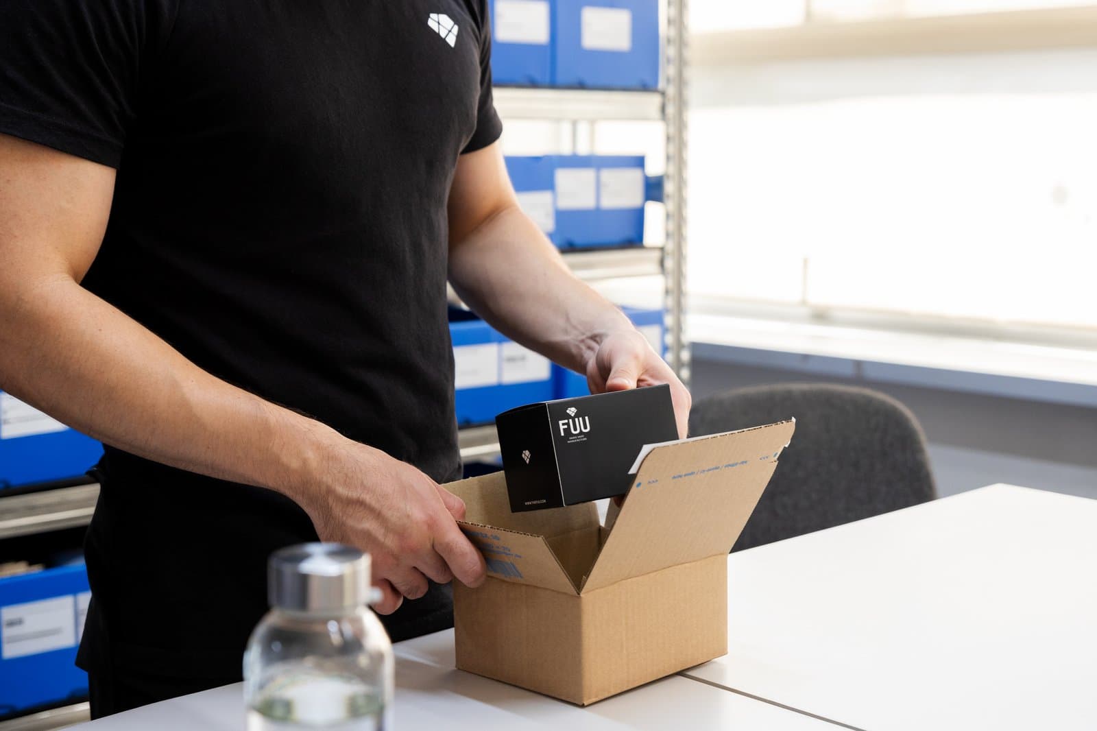 Une personne place une boîte Fuu dans un carton de commande.